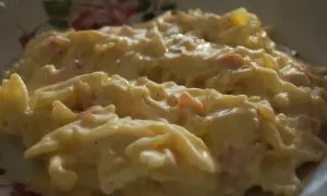 Makaron farfalle w kremowym sosie śmietanowym z kawałkami szynki.