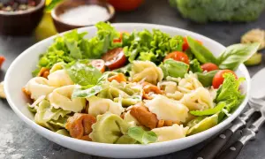 Sałatka z kolorowymi tortellini, pomidorkami koktajlowymi, sałatą i bazylią.