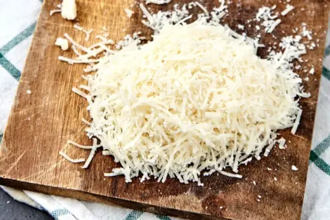 Stos tarty parmezan na drewnianej desce.