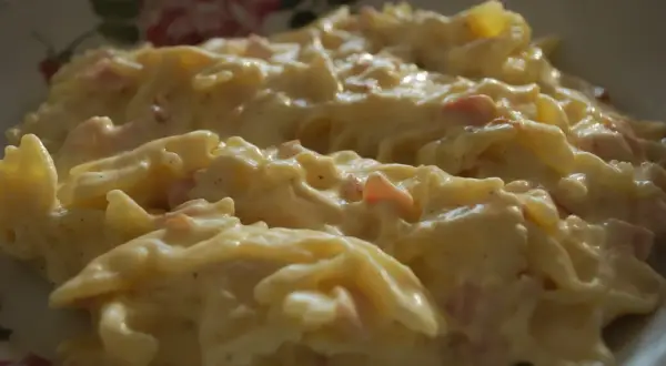 Makaron farfalle w kremowym sosie śmietanowym z kawałkami szynki.