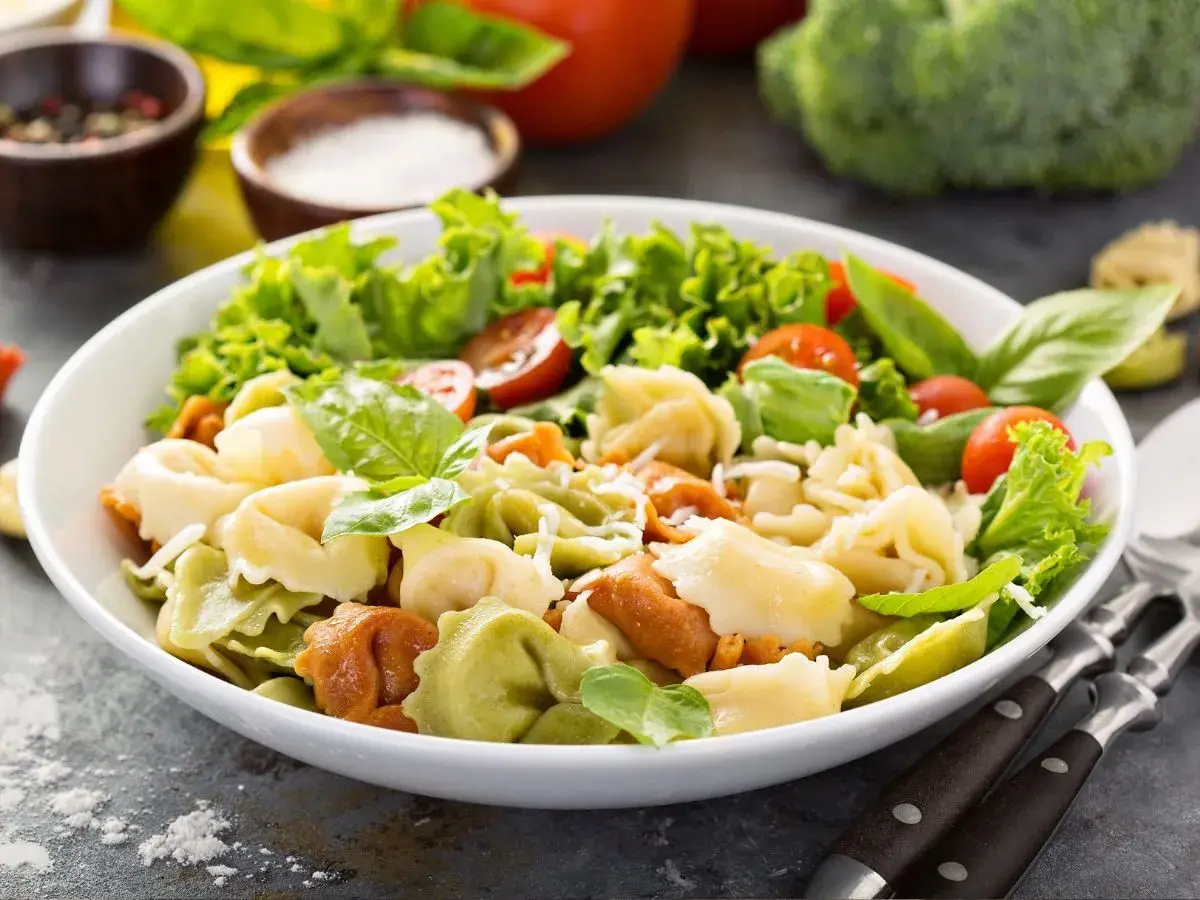 Sałatka z kolorowymi tortellini, pomidorkami koktajlowymi, sałatą i bazylią.