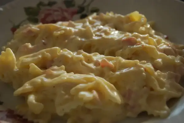Makaron farfalle w kremowym sosie śmietanowym z kawałkami szynki.
